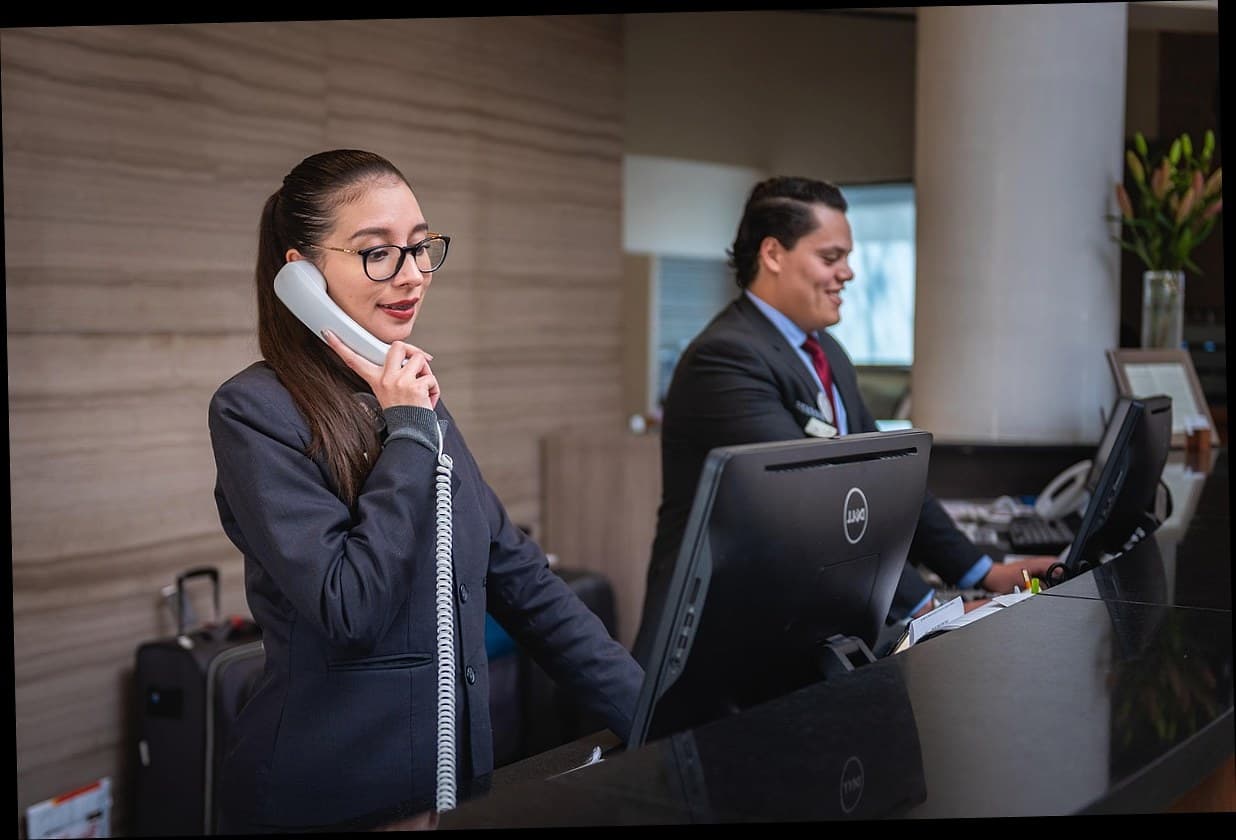 Resepsionis klinik kecantikan menggunakan aplikasi kasir modern di meja depan