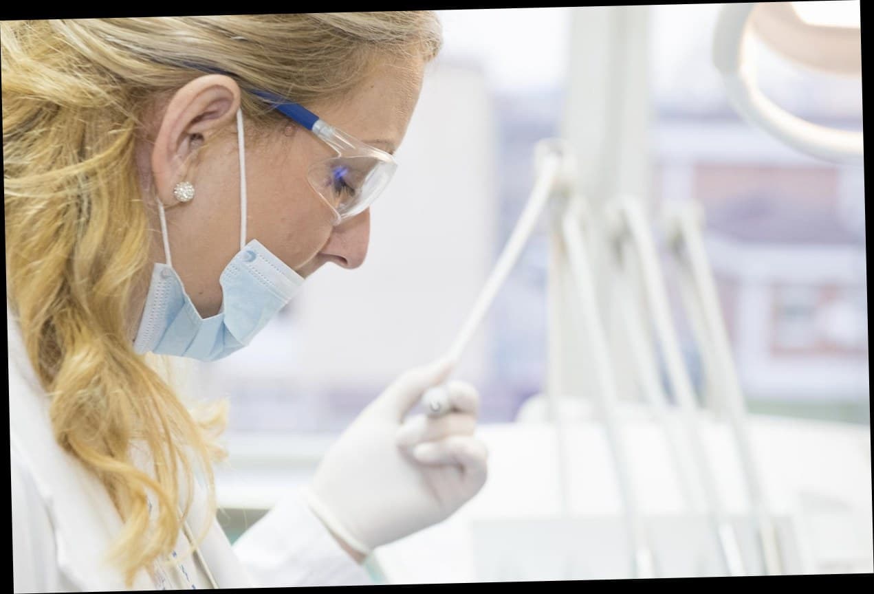 Pasien klinik kecantikan menggunakan aplikasi loyalitas di smartphone sambil tersenyum