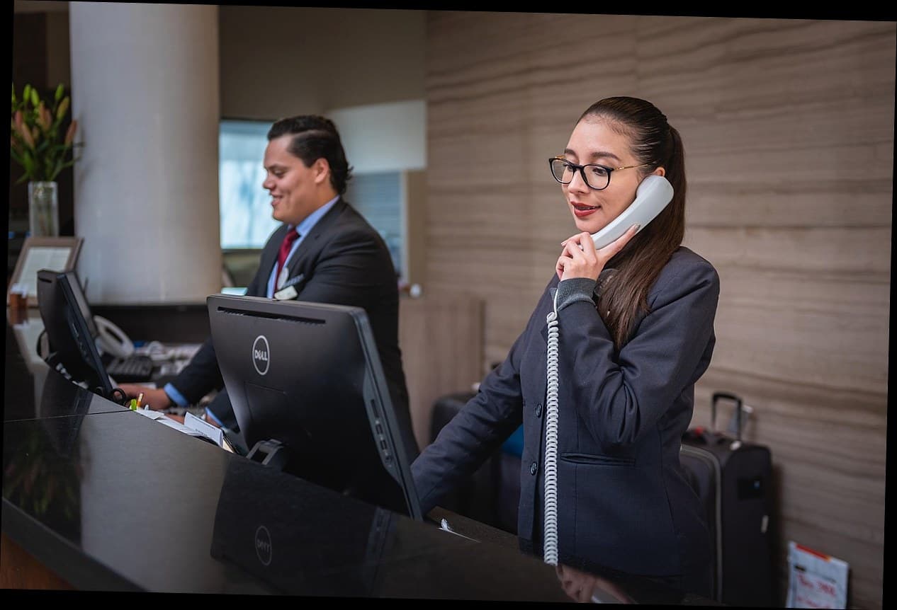 Resepsionis klinik kecantikan sedang mengelola sistem reservasi digital