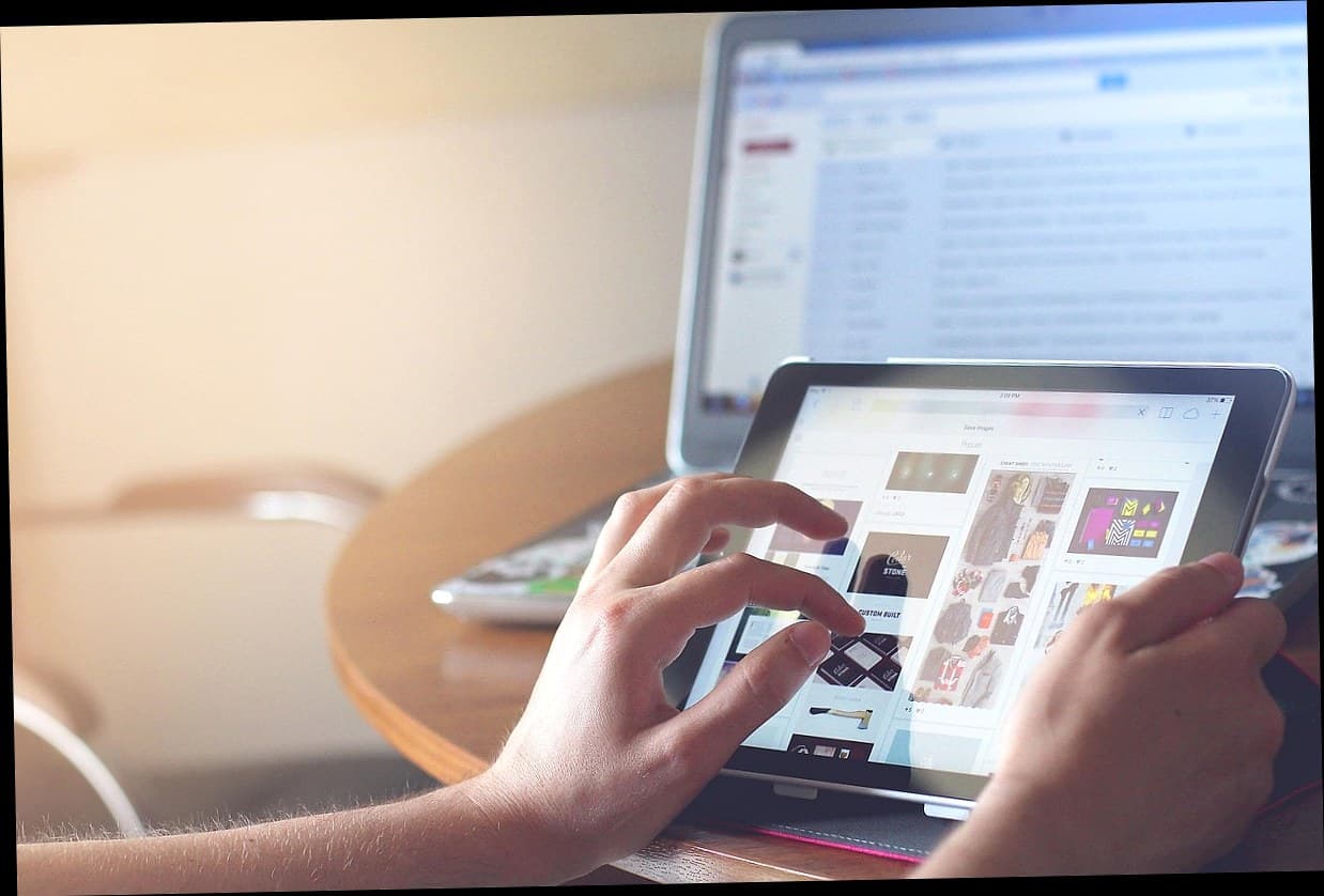 Seorang manajer klinik kecantikan menggunakan aplikasi digital di tablet untuk mengelola pelanggan.