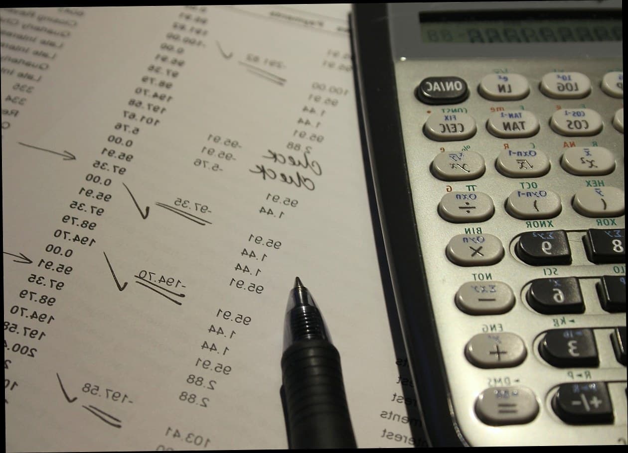 Clinic owner analyzing profit and loss report on laptop with charts showing financial data