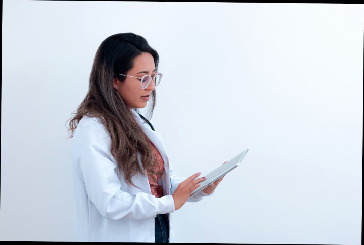 Pemilik klinik kecantikan sedang mengecek data pasien menggunakan tablet
