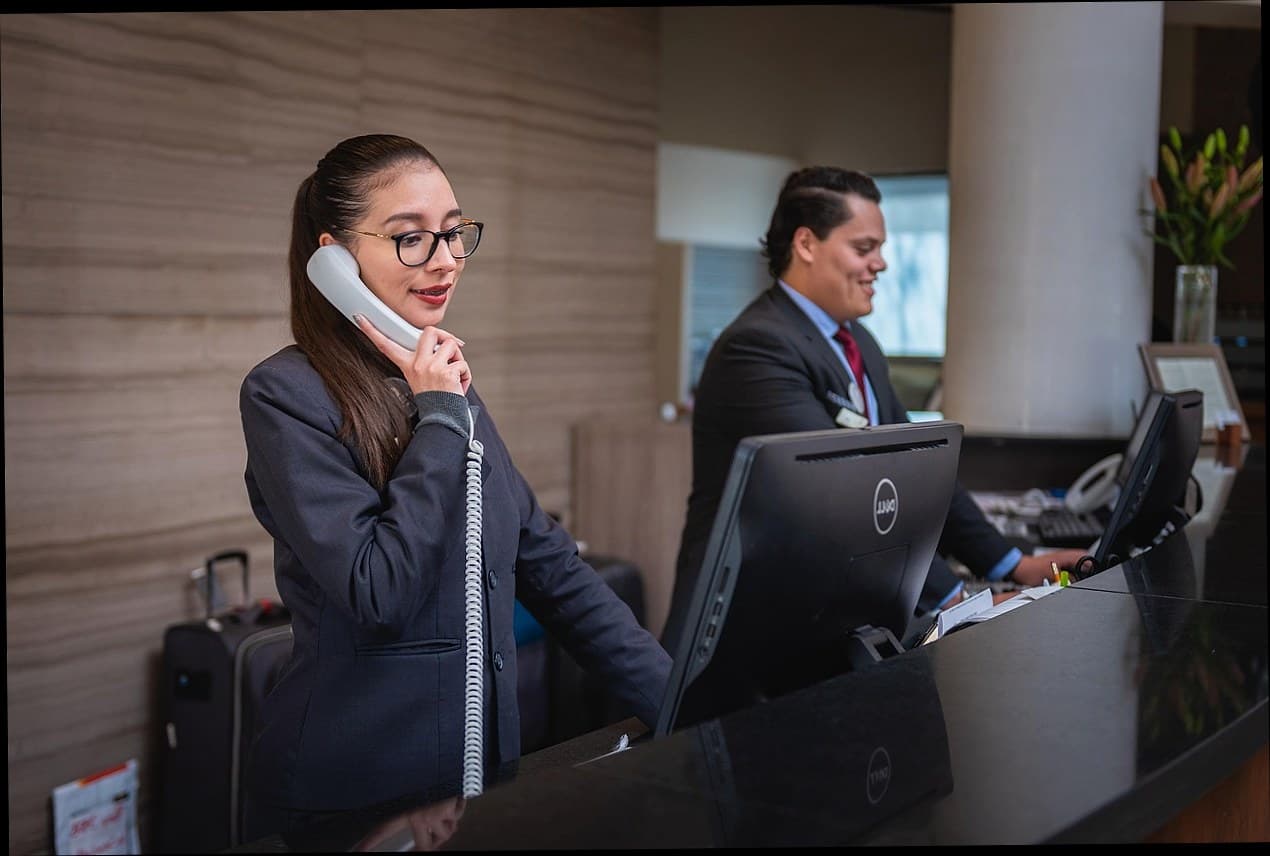 Resepsionis klinik estetika menyambut pelanggan dengan senyum