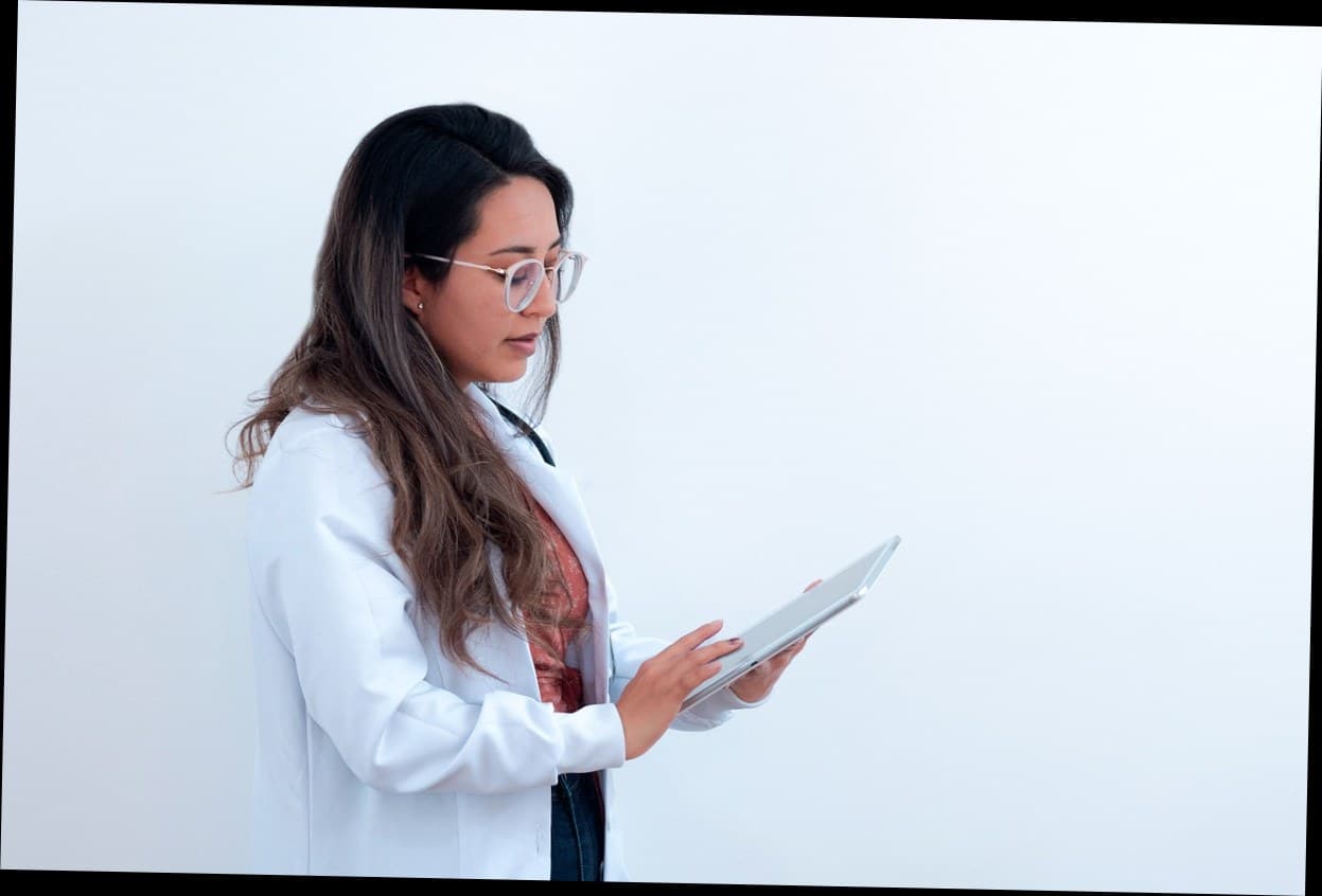 Pemilik klinik kecantikan menggunakan tablet untuk mengelola sistem digital pelanggan