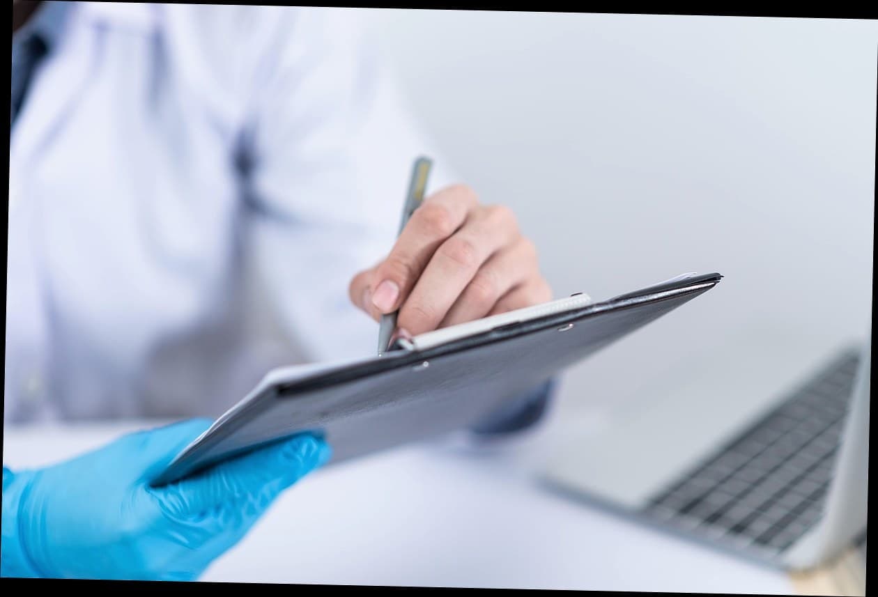 Dokter klinik kecantikan sedang konsultasi dengan pasien di ruang praktik modern