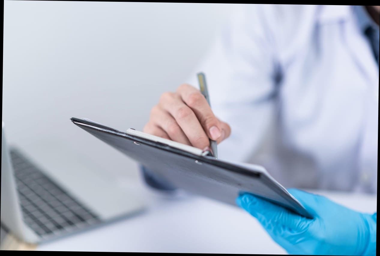 Konsultan kecantikan menunjukkan katalog treatment kepada pelanggan di klinik