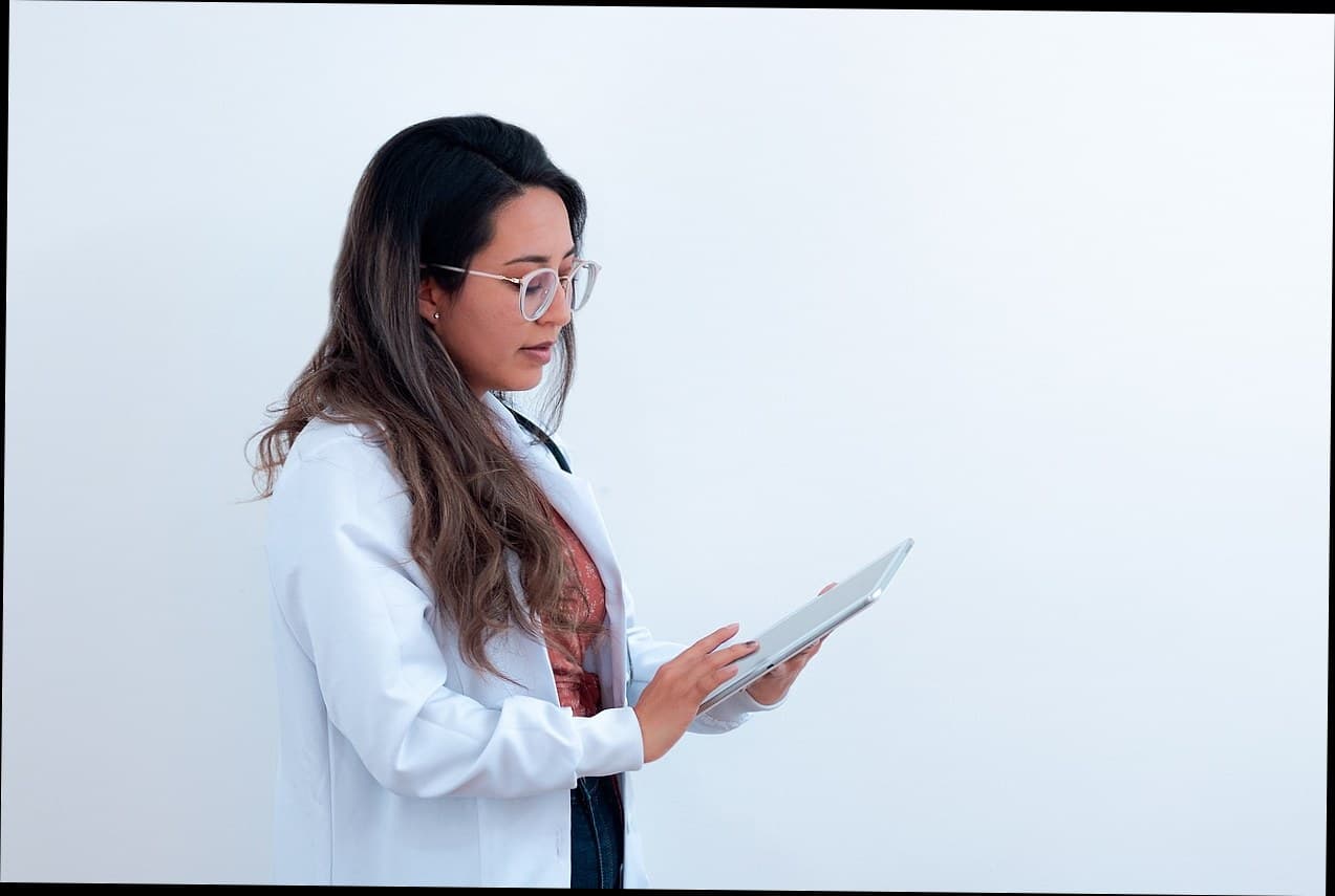 Seorang dokter estetika menggunakan tablet untuk mengelola operasional klinik kecantikan modern.